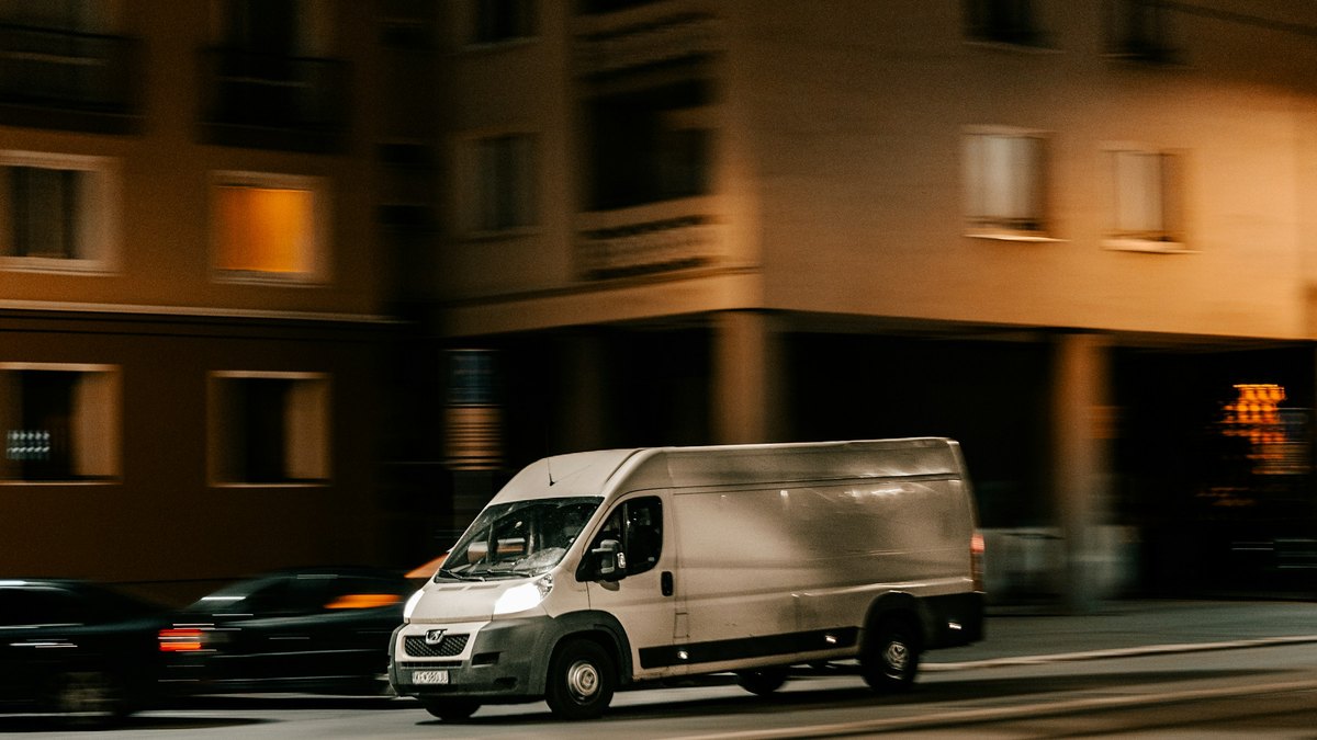 夜の街を走る白い配送用バン