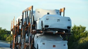 カバーをかけた新車を積んで走るキャリアカー