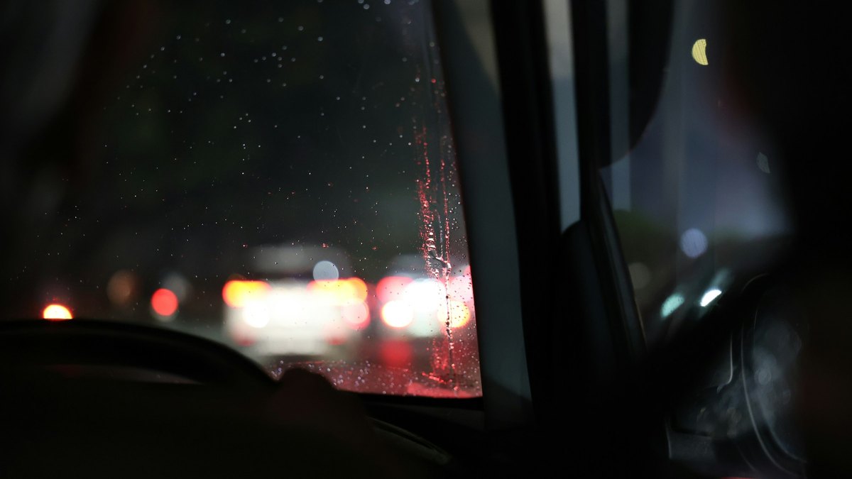 雨の夜に車内からフロントガラス越しに見た道路
