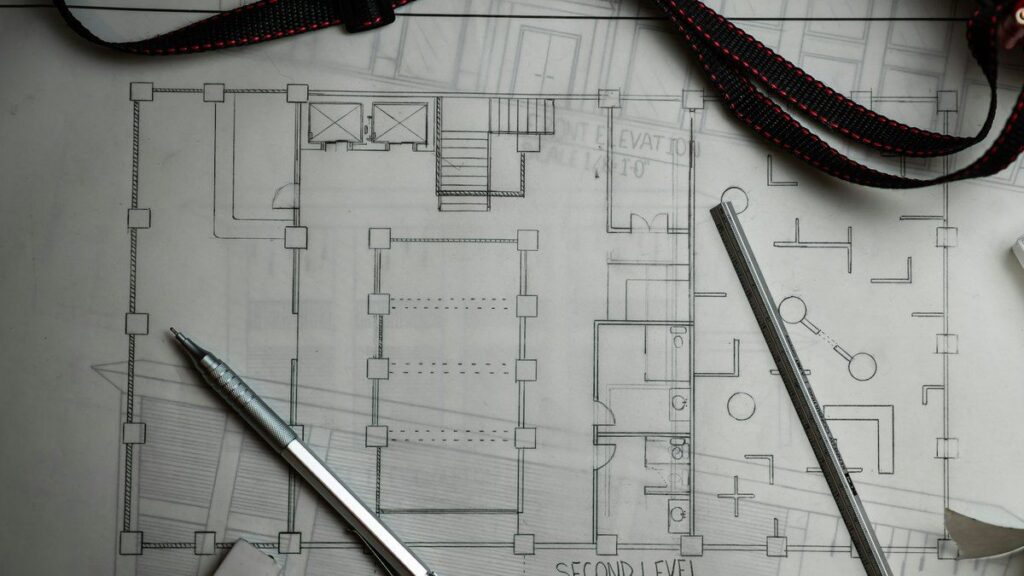建築図面の上に置かれた製図用シャープペンシルとスケール