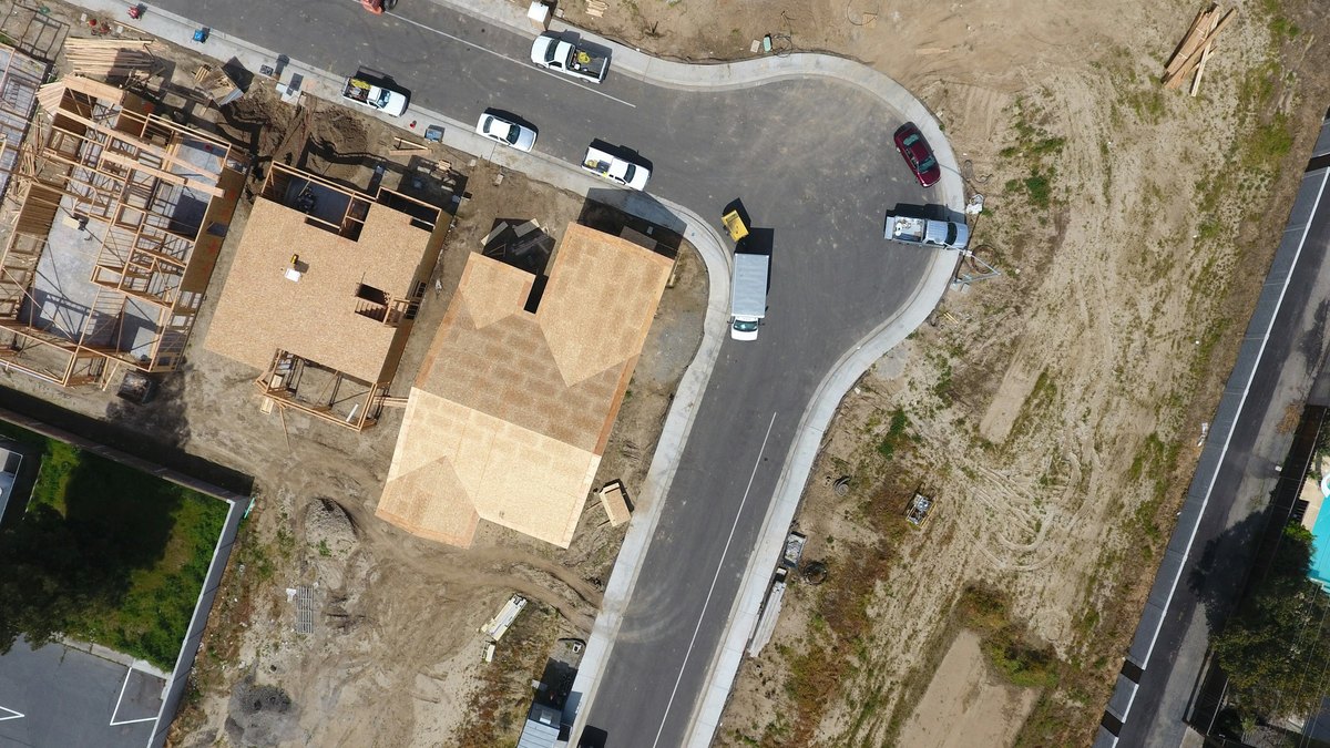 建設中の住宅と道路を真上から撮影した写真。造成地と工事車両が写っている