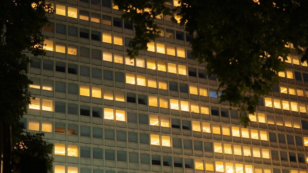 夜に窓の明かりがともるビル
